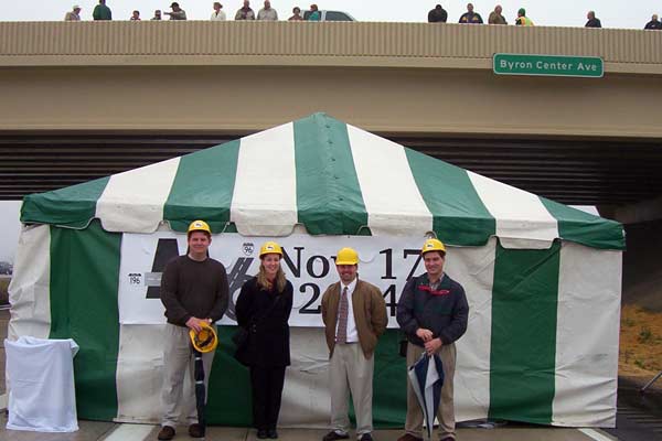 After the actual cutting of the ribbon spanning the highway, yours truly and three co-workers from the Grand Valley Metropolitan Council posed in front of the event tent on the westbound lanes of the freeway.